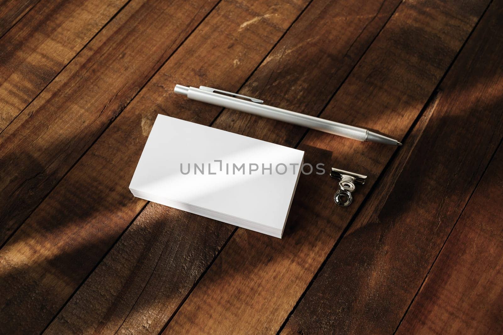 Photo of blank business cards and pen on vintage wooden table background. Blank template for placing your design. Mockup for branding identity.