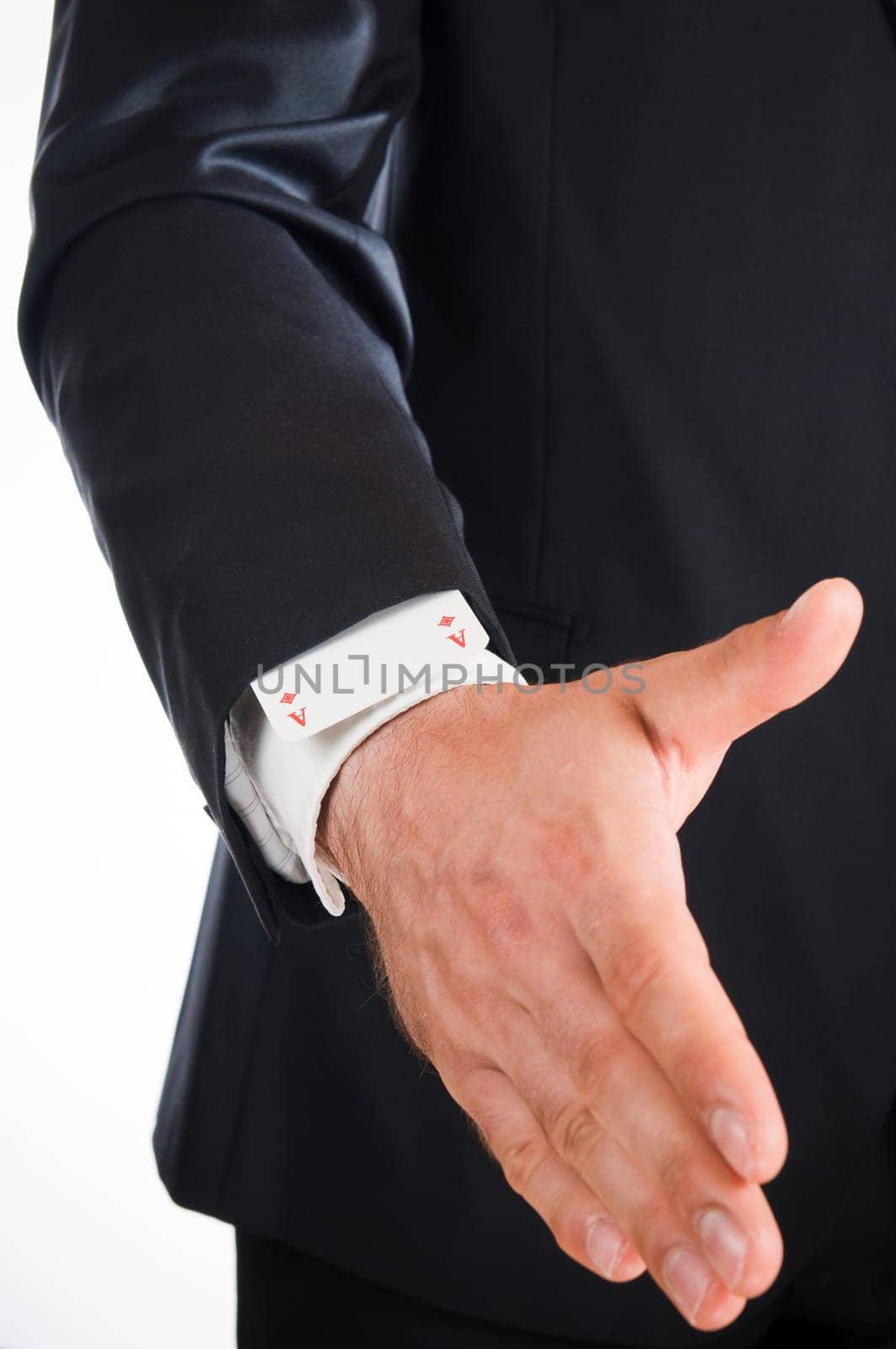 Frontal view of the hand of a man dressed in a suit with an ace in his sleeve isolated on white.