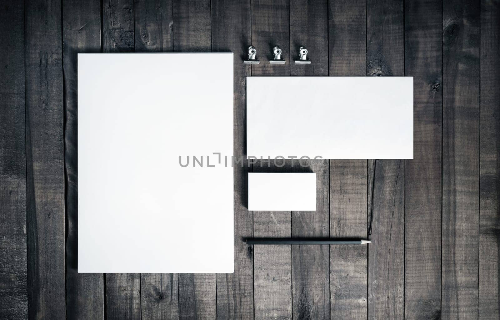 Photo of blank stationery set on wood background. Blank stationery and corporate identity template. Blank letterhead, business cards, envelope and pencil. Responsive design mockup. Top view.