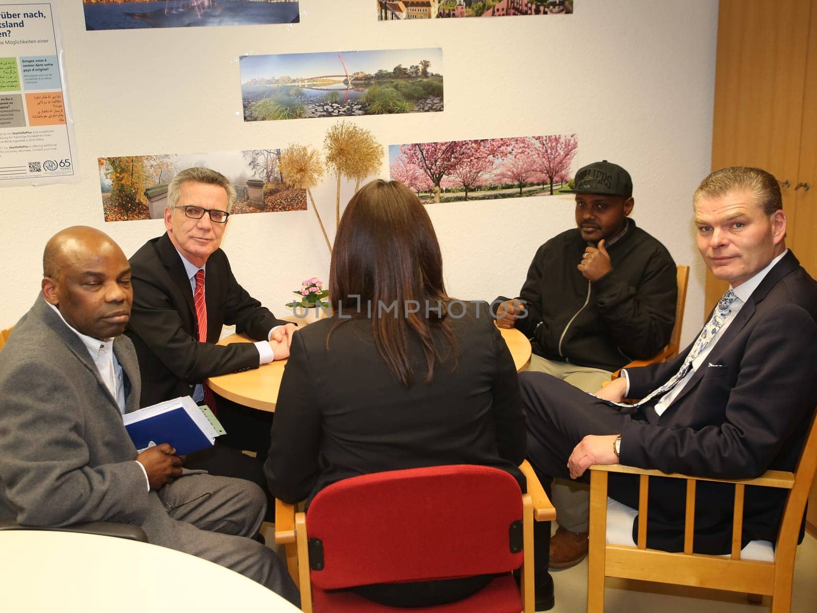 Federal Interior Minister Thomas de Maizière (CDU) (2nd from left) with refugee Hashem Gassin (2nd right) from Sudan in Magdeburg city mission on 21.2.17