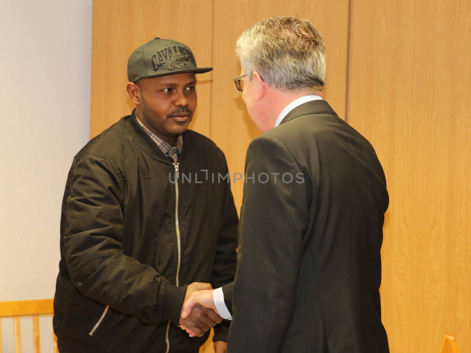 Federal Interior Minister Thomas de Maizière (CDU) welcomes refugee Hashem Gassin from Sudan to the Magdeburg City Mission on 21.02.2017