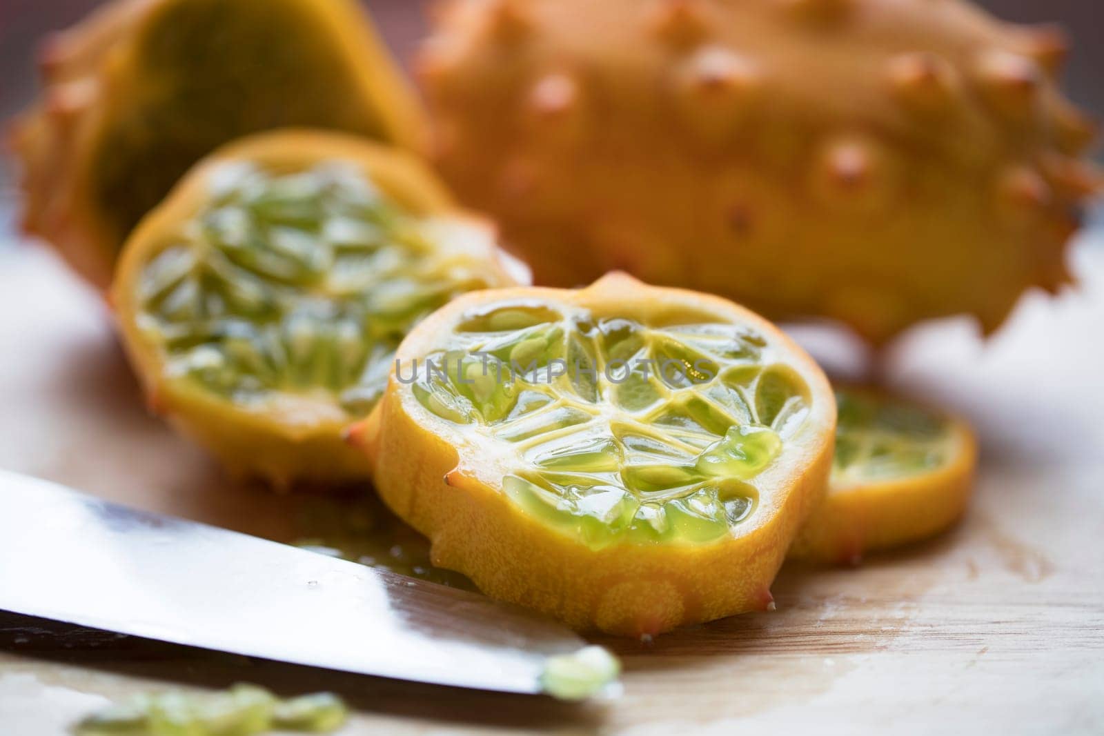 Slices of kiwano fruit with knife.