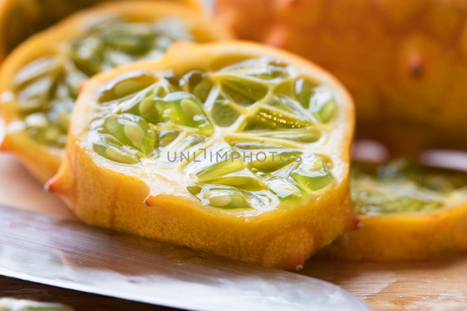 Close up of kiwano fruit slices with knife.