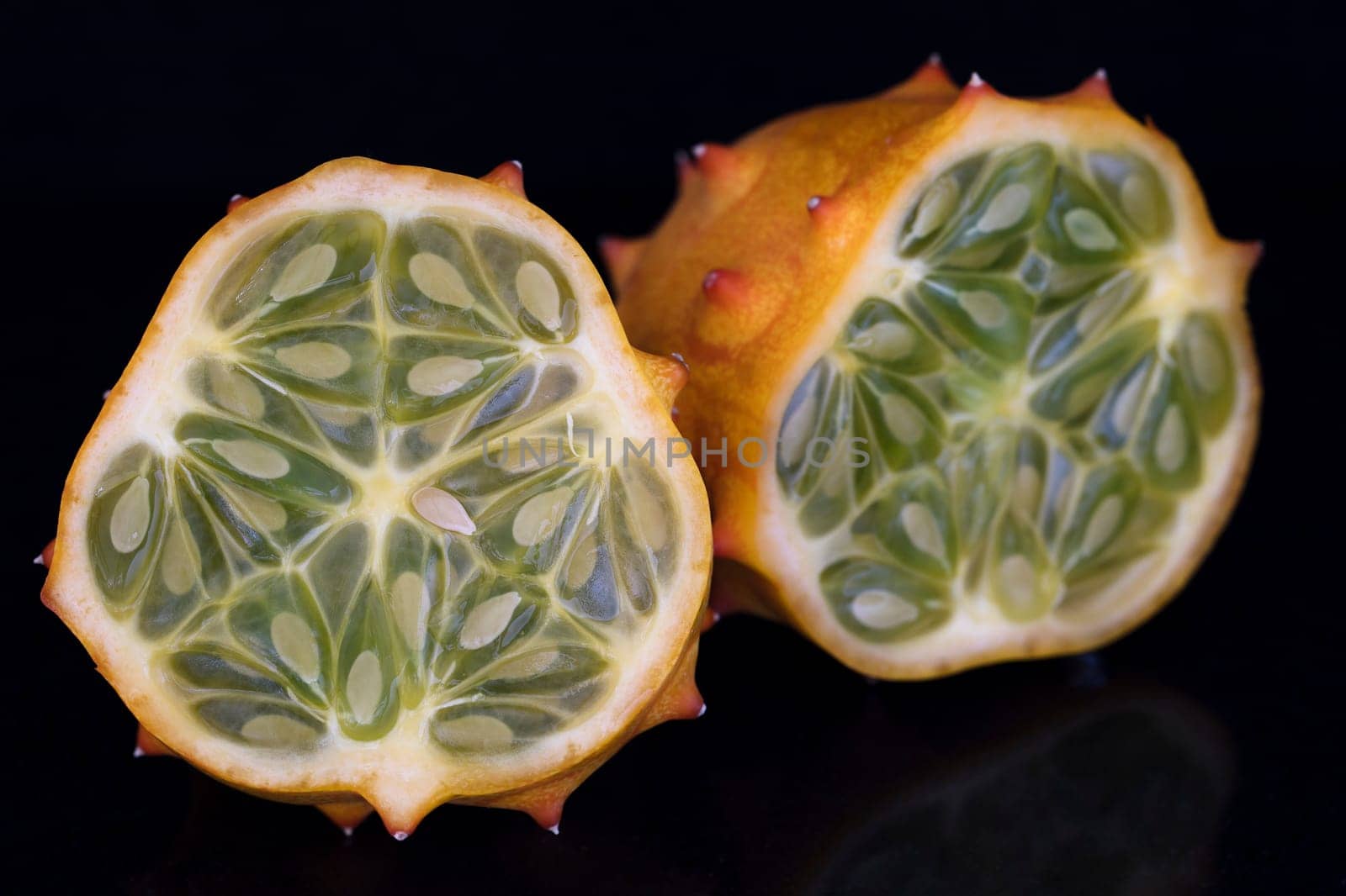 Kiwano fruit cut in half on black background