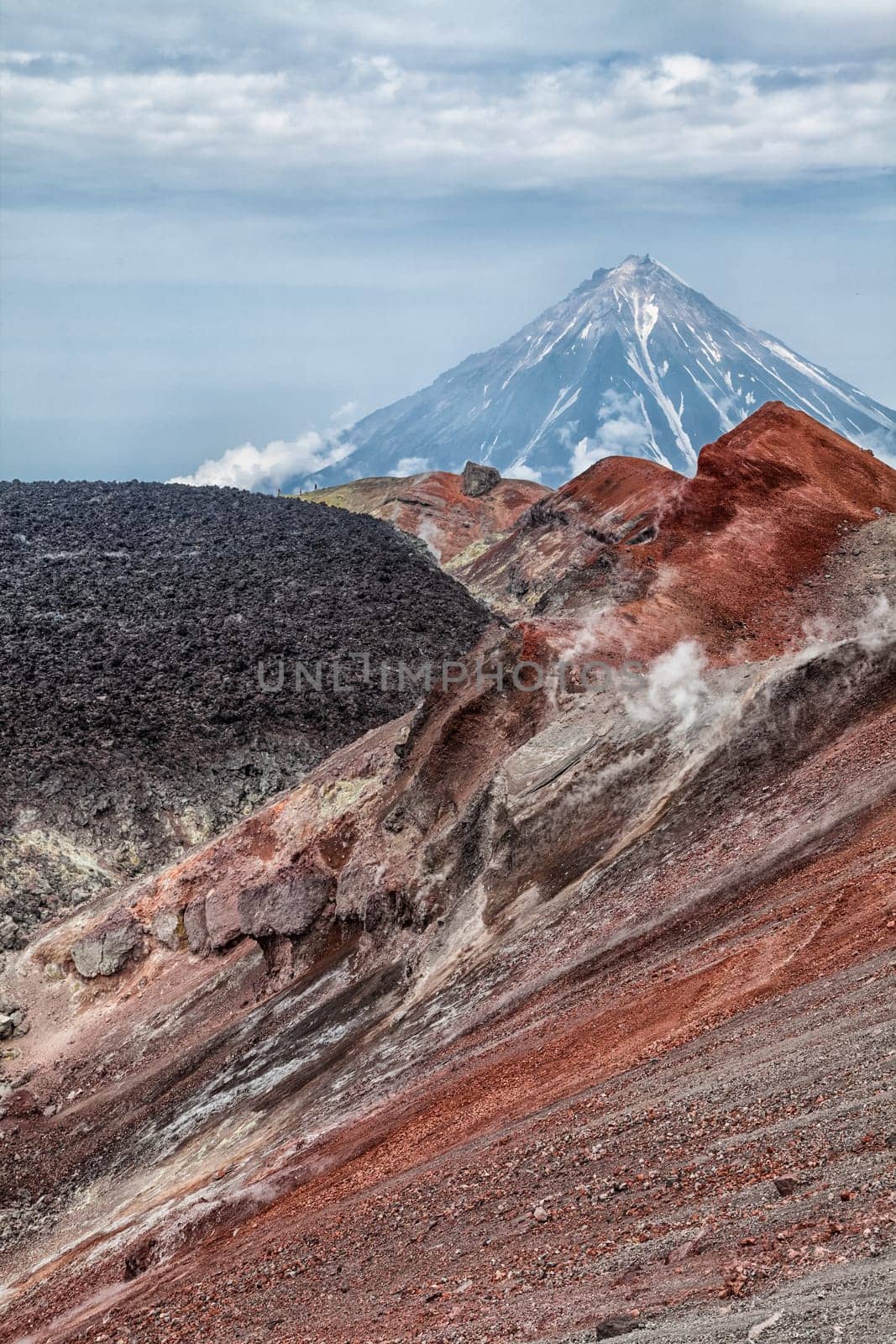 Mountains and volcanoes. Beautiful landscape of Kamchatka Peninsula: summer panoramic view of Mountain Range Vachkazhets, mountain lake and clouds in blue sky on sunny day. Eurasia, Russian Far East, Kamchatka Region.