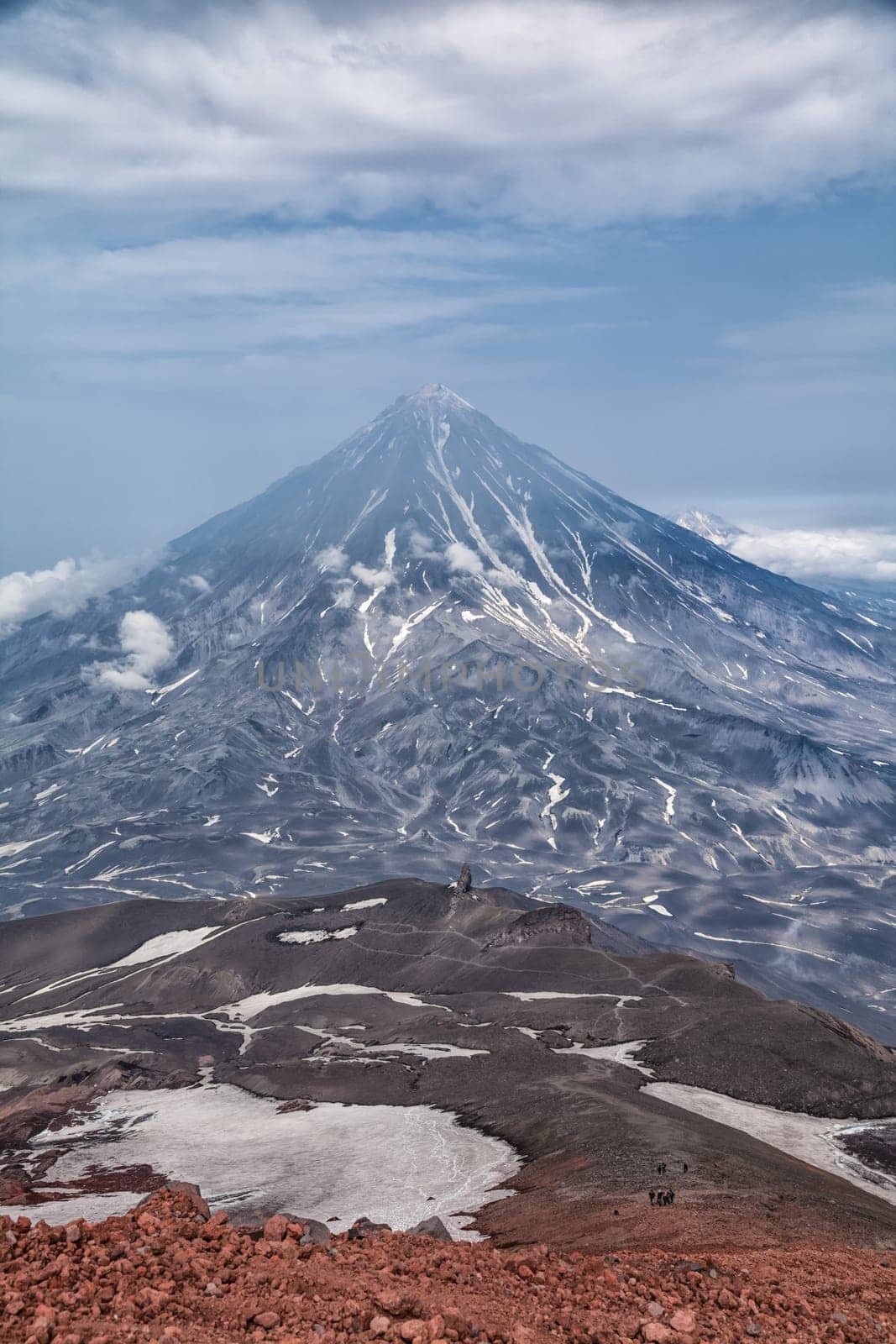 Mountains and volcanoes. Beautiful landscape of Kamchatka Peninsula: summer panoramic view of Mountain Range Vachkazhets, mountain lake and clouds in blue sky on sunny day. Eurasia, Russian Far East, Kamchatka Region.