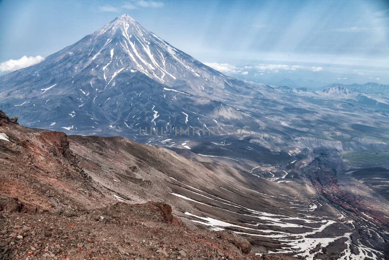 Mountains and volcanoes. Beautiful landscape of Kamchatka Peninsula: summer panoramic view of Mountain Range Vachkazhets, mountain lake and clouds in blue sky on sunny day. Eurasia, Russian Far East, Kamchatka Region.