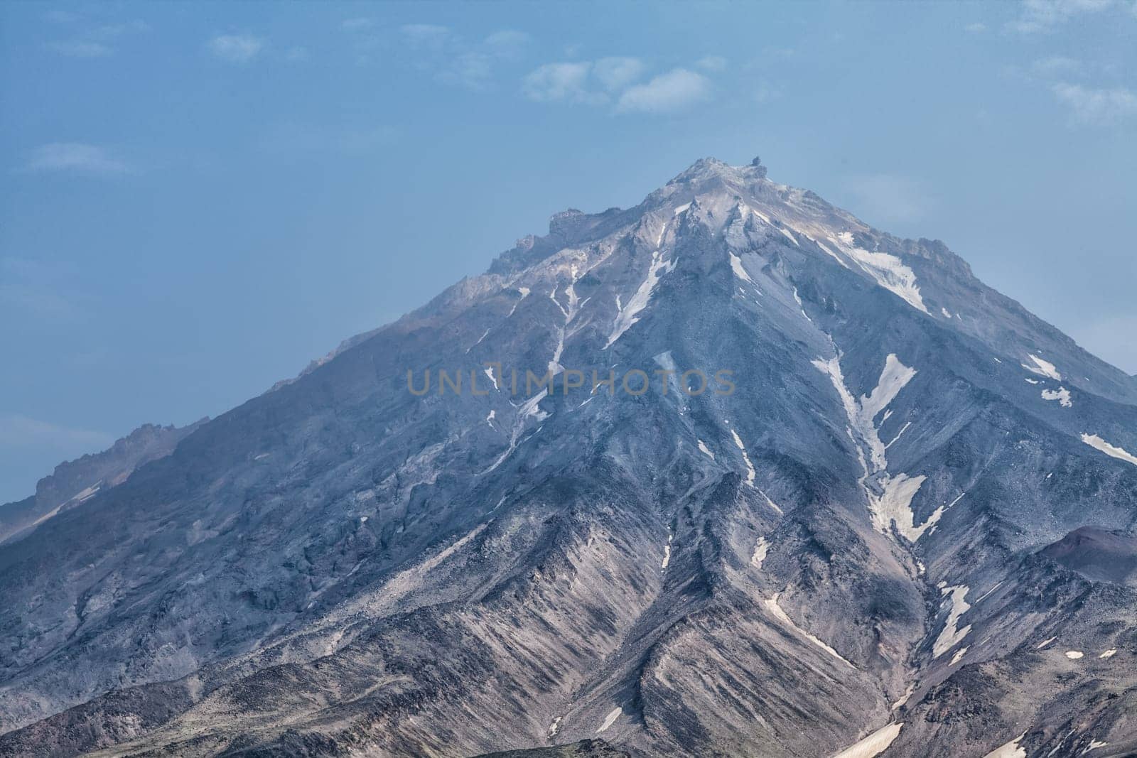 Mountains and volcanoes. Beautiful landscape of Kamchatka Peninsula: summer panoramic view of Mountain Range Vachkazhets, mountain lake and clouds in blue sky on sunny day. Eurasia, Russian Far East, Kamchatka Region.