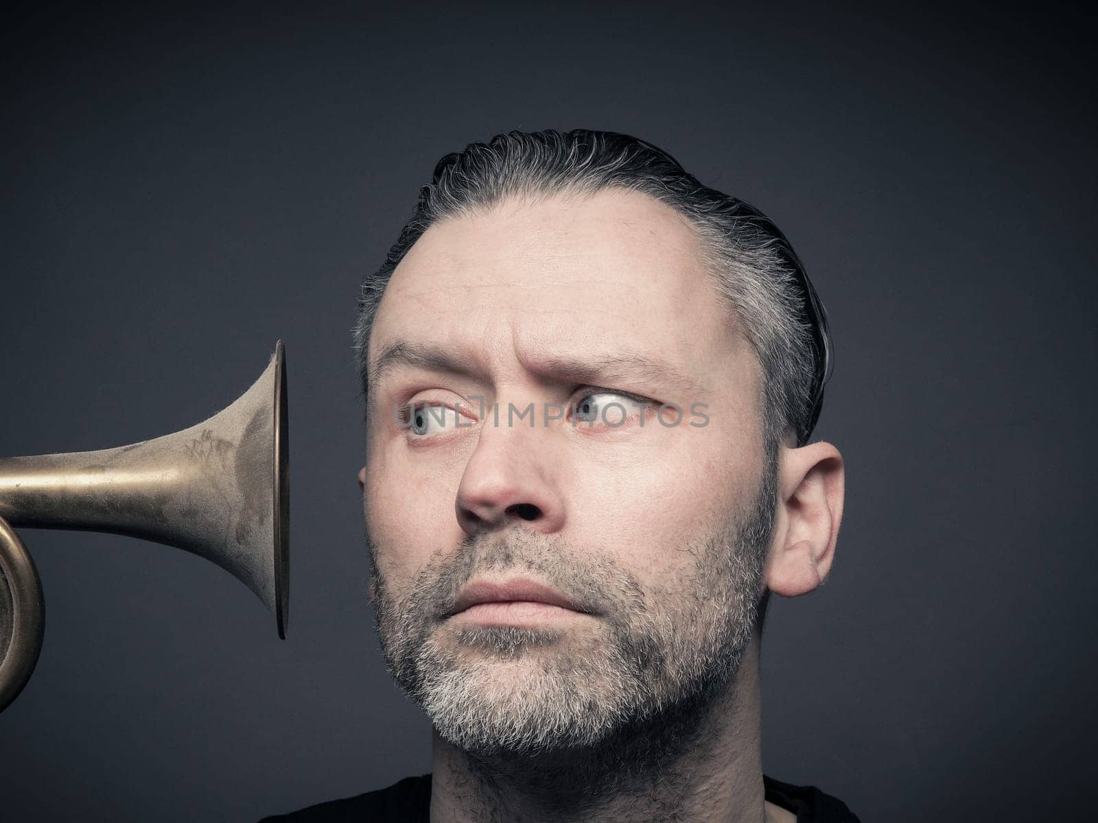 Handsome man with an old trumpet from side