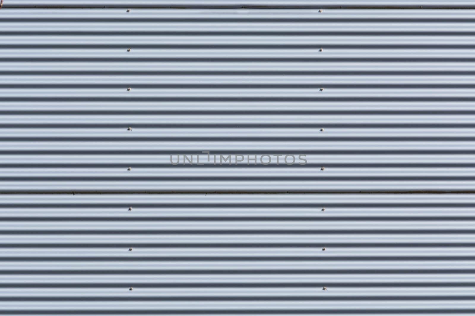 Silver-colored metal wall corrugated sheet metal as background..