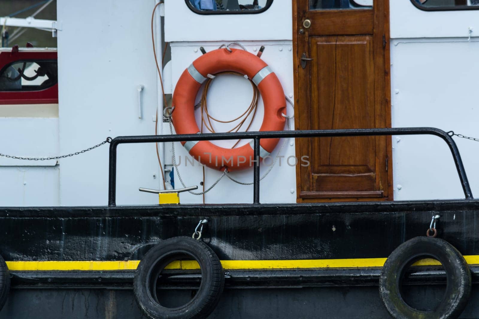 Side view of an old steel ship with lifebuoy in the harbor.
