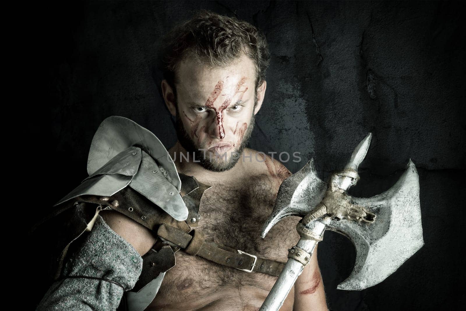 Ancient warrior or Gladiator posing against a dark background with an axe