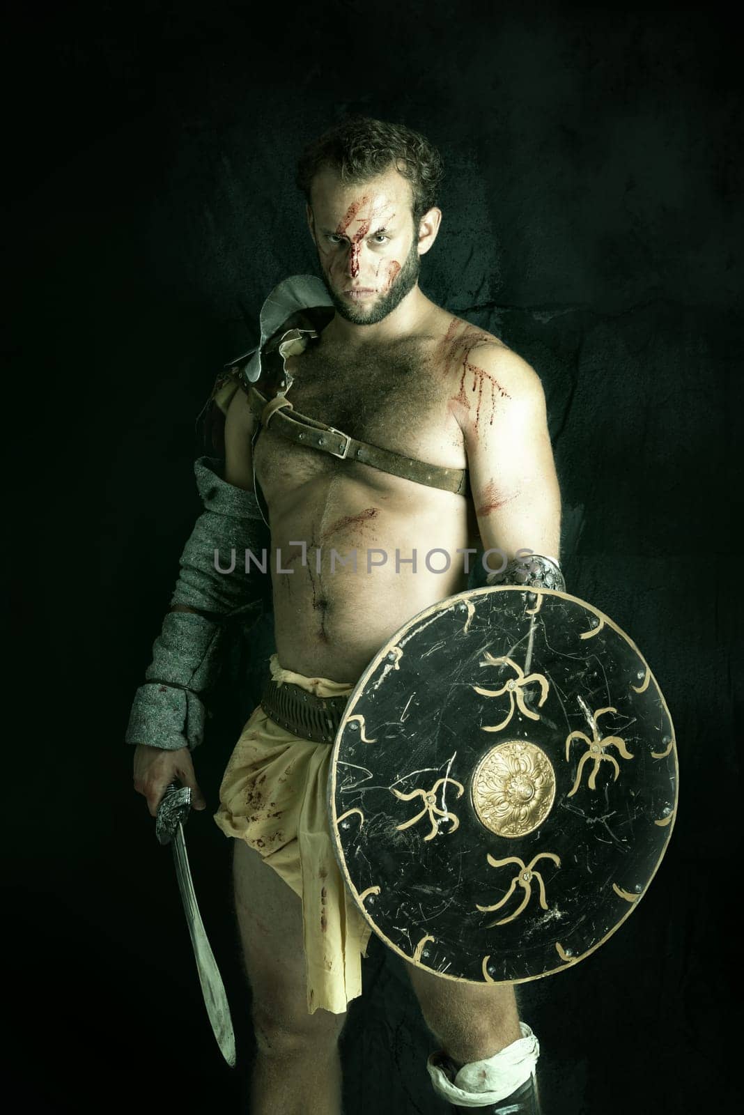 Ancient warrior or Gladiator posing against a dark background with sword