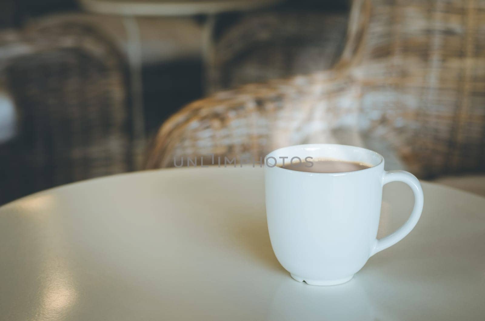 Cup of coffee on wooden table in coffee shop. Coffee break in morning, selective focus.