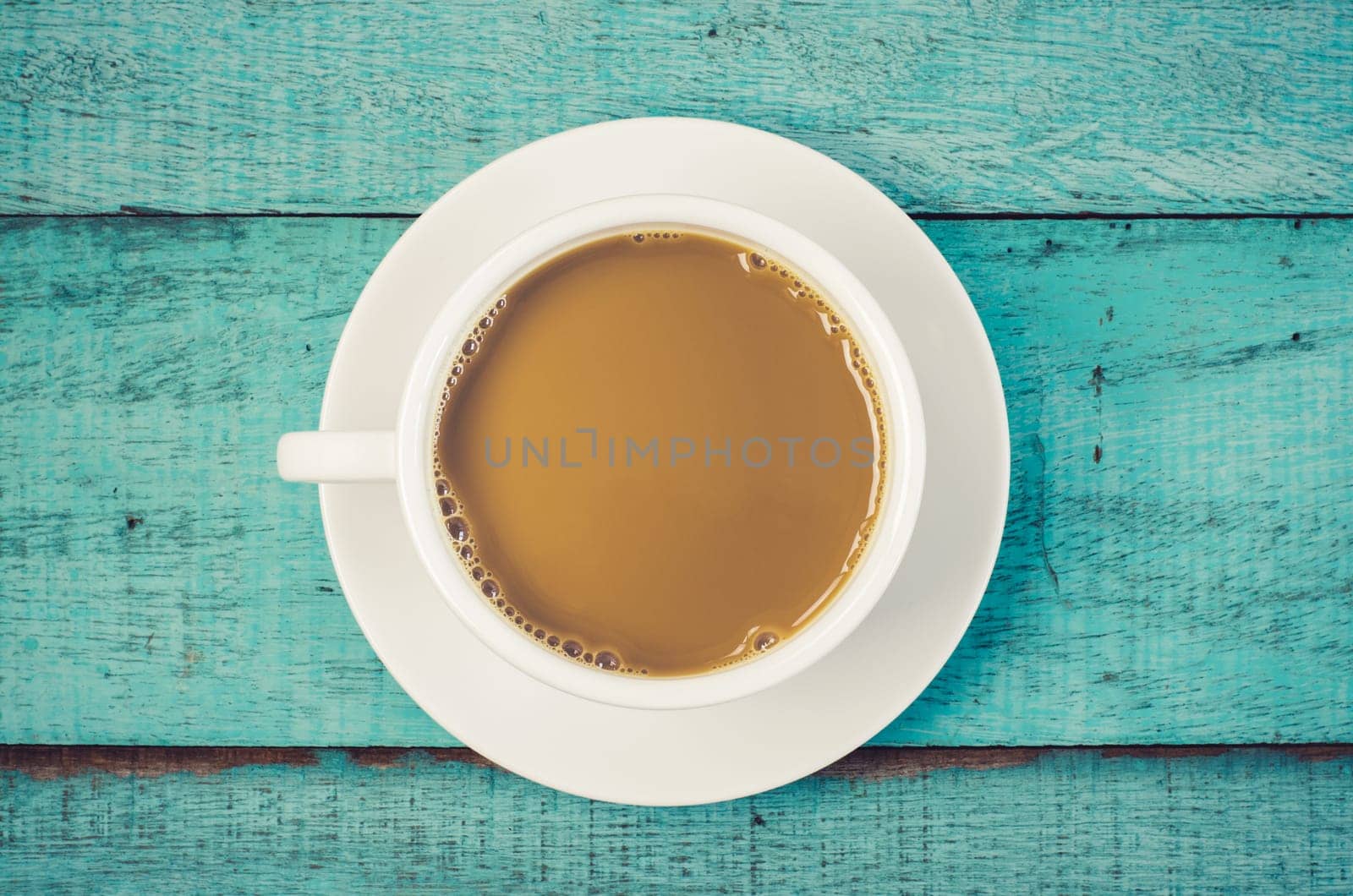 Top view cup of coffee on blue wooden table. Vintage filter.