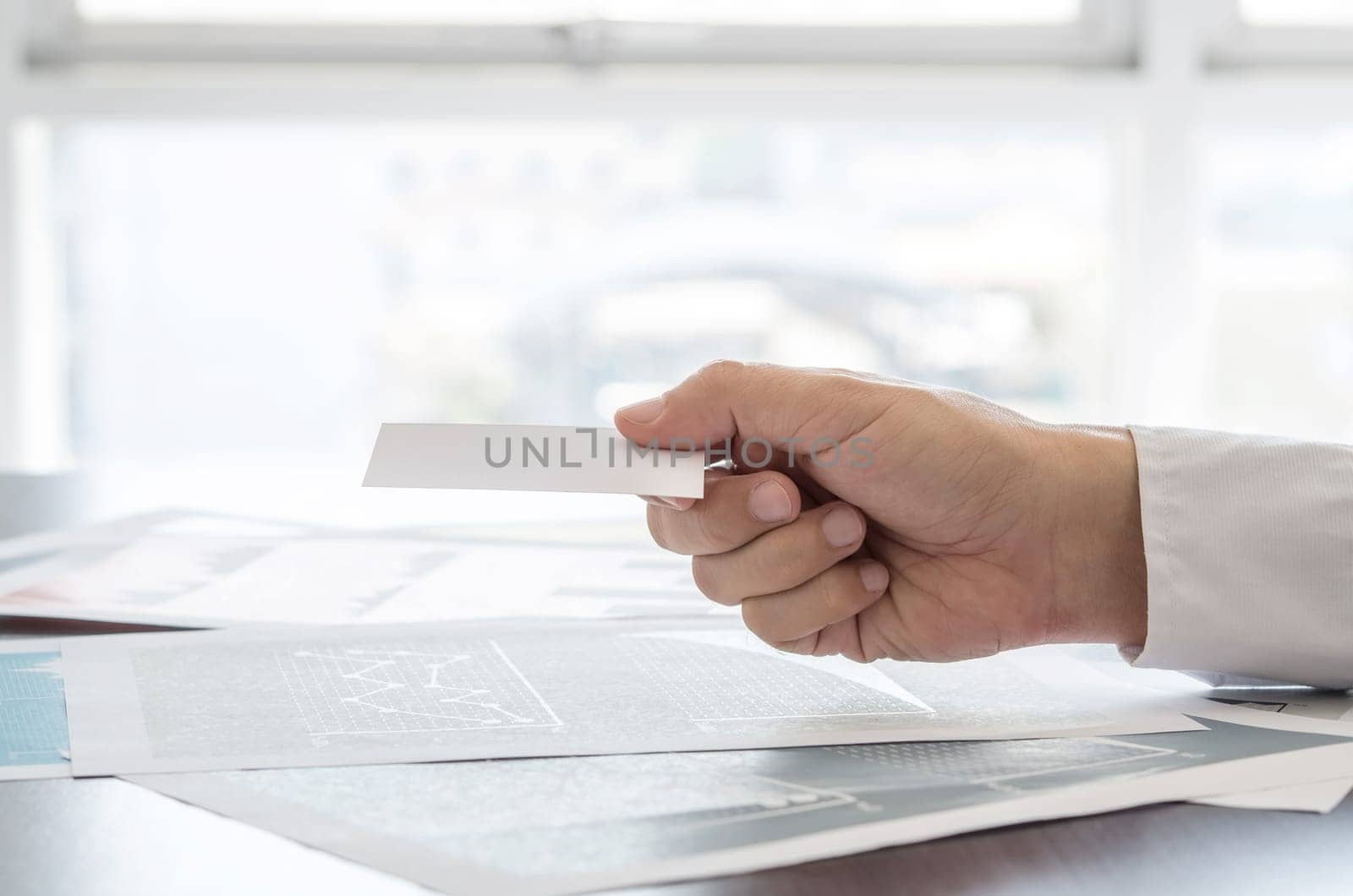 Close-up businessman holding empty business card. Business, office concept.