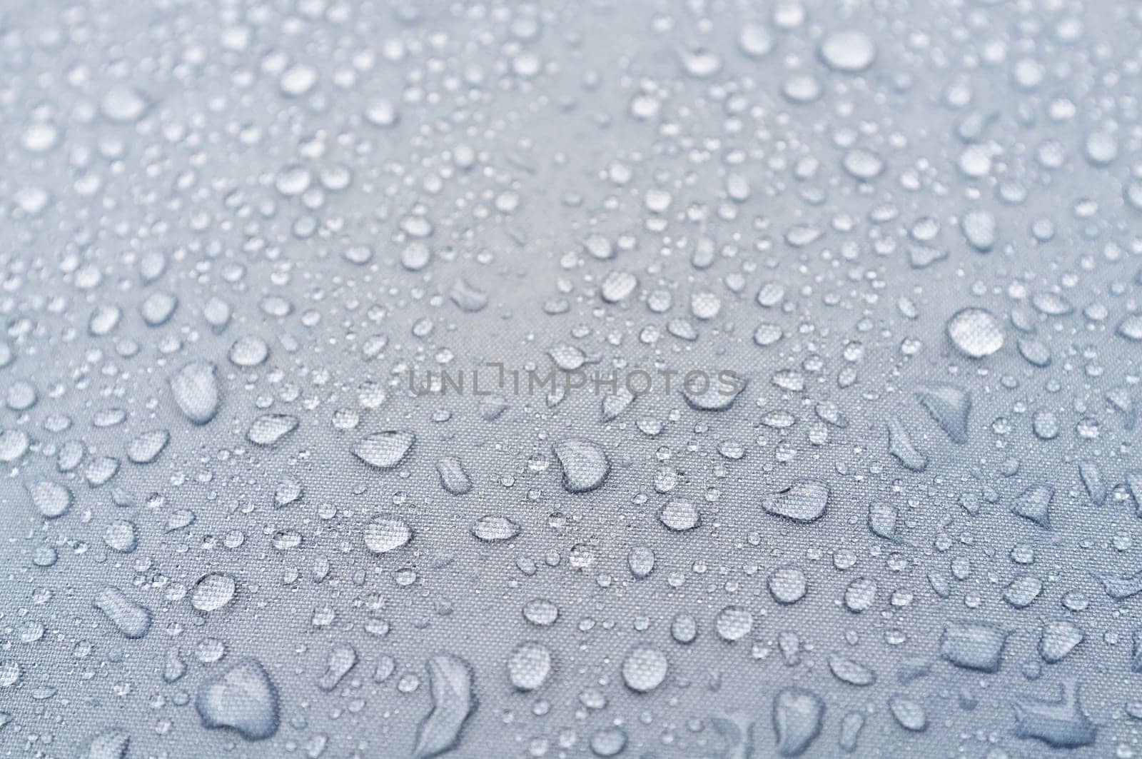 Water droplets on grey fiber waterproof fabric. abstract background.