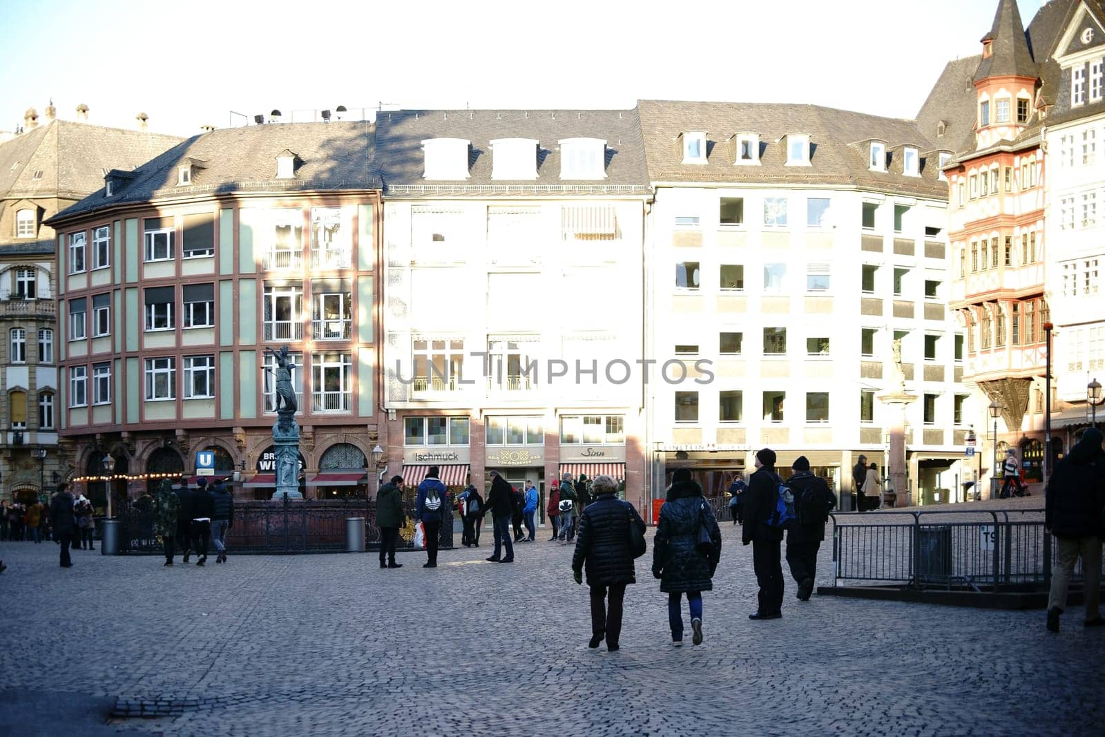 Frankfurt,Germany - January 05,2017: Visitors and tourists visit the Römerberg with historic buildings and the Fountain of Justice on January 5,2017 in Frankfurt.