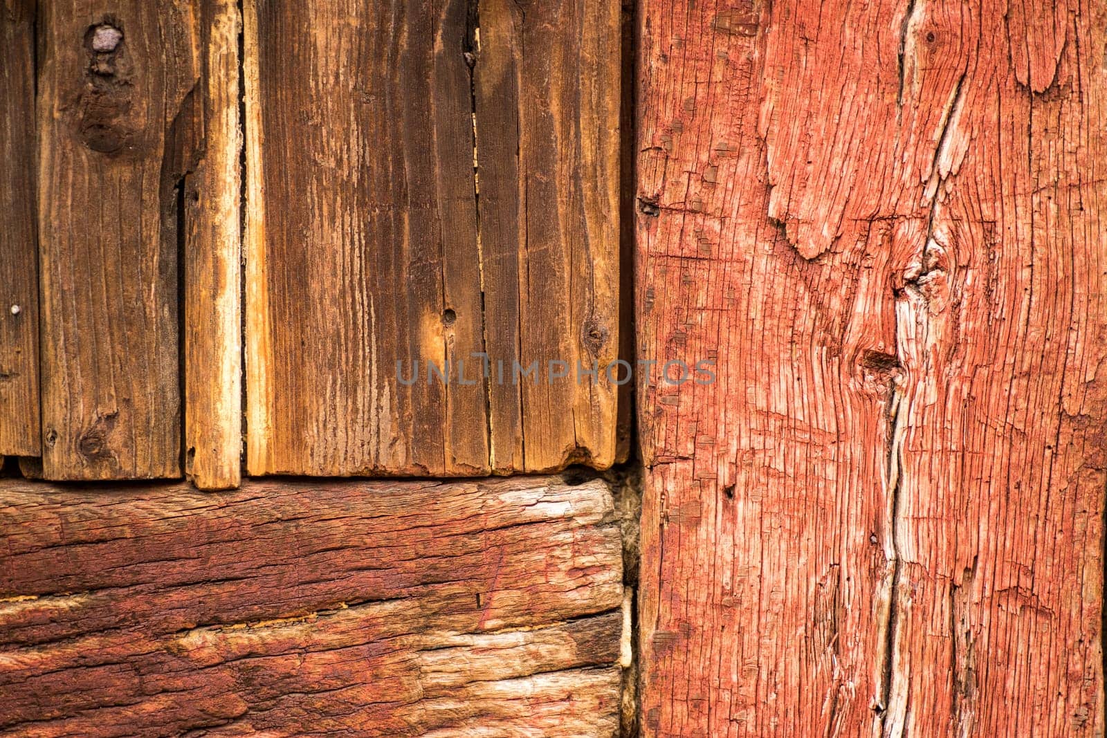 Detail of building with both cracked red painted wood and raw vintage wood