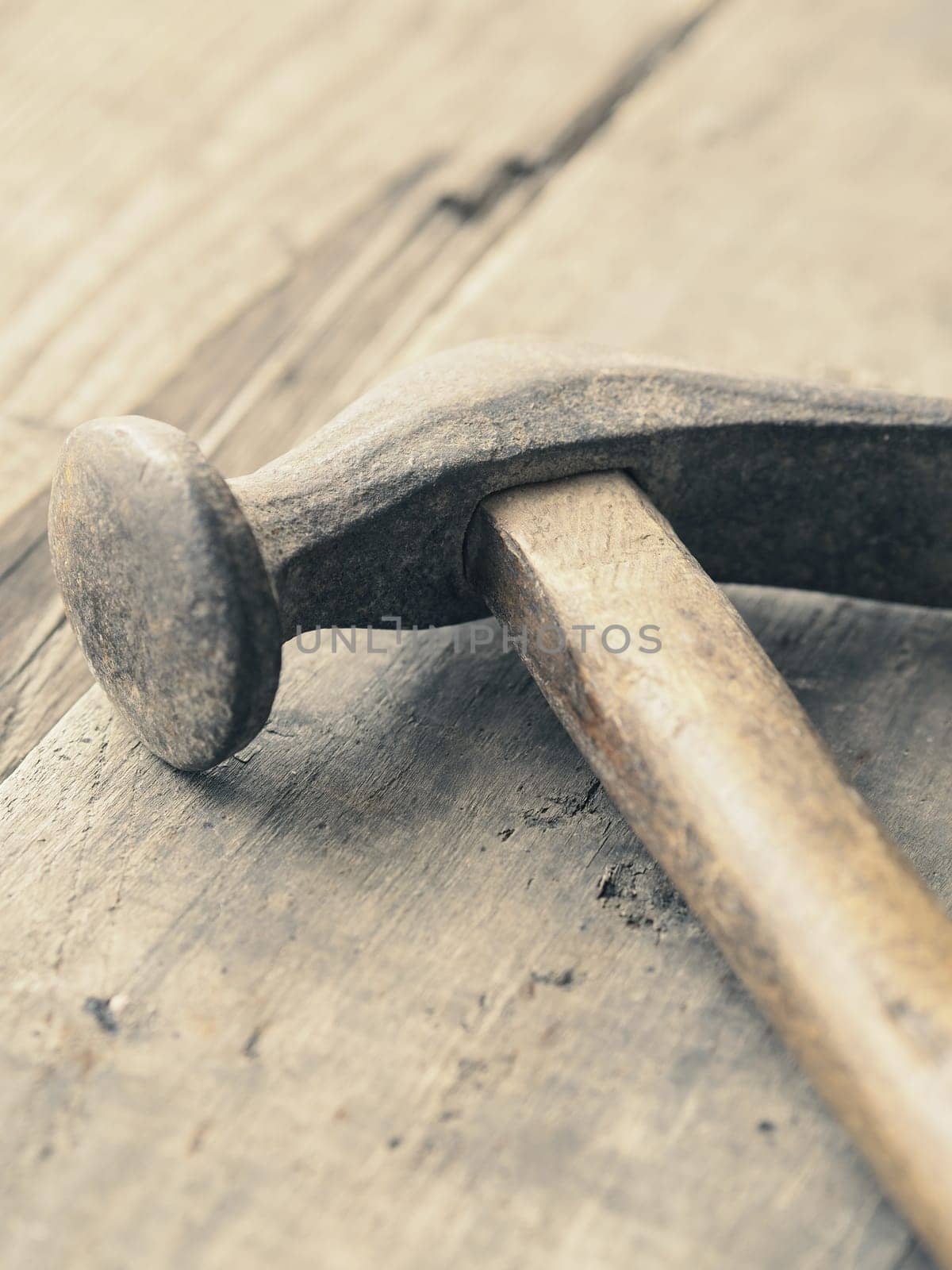 Old used vintage hammer on a wooden workbench