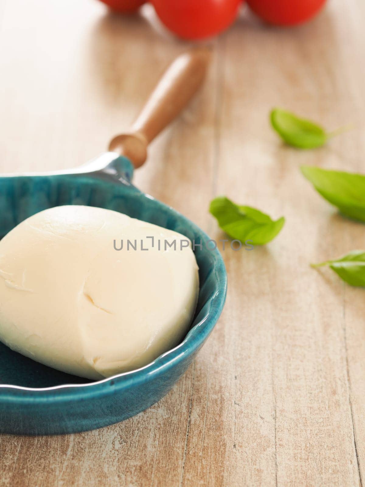 Fresh organic mozzarella with basil and tomatoes in a kitchen