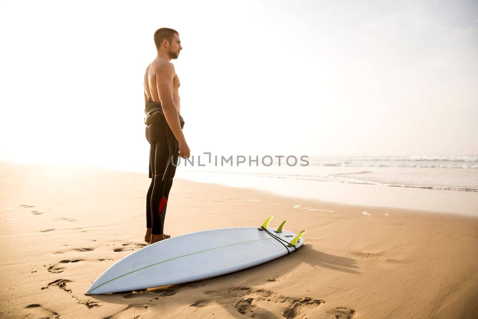 A surfer with his surfboard at the beach