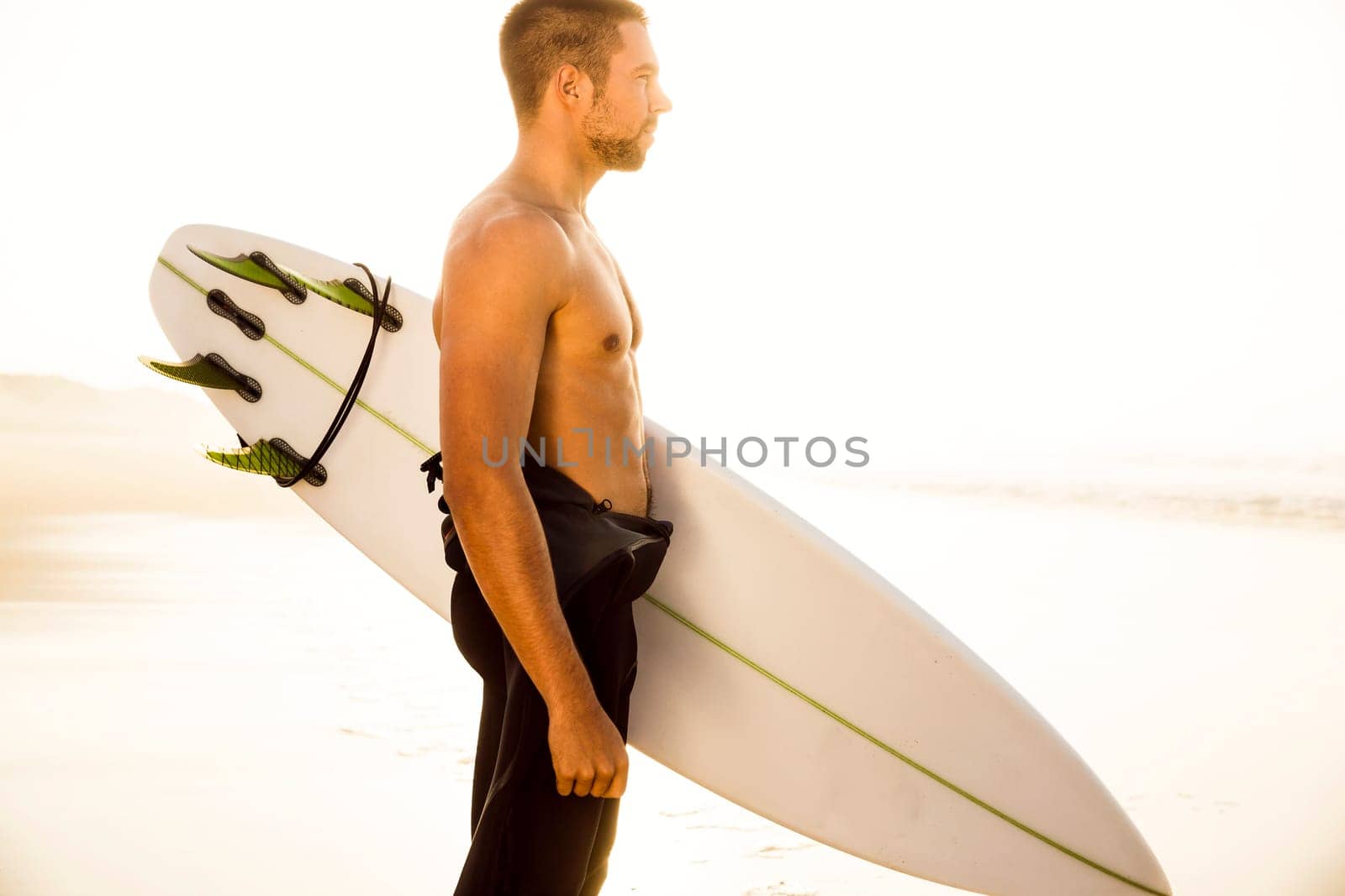 A surfer with his surfboard at the beach