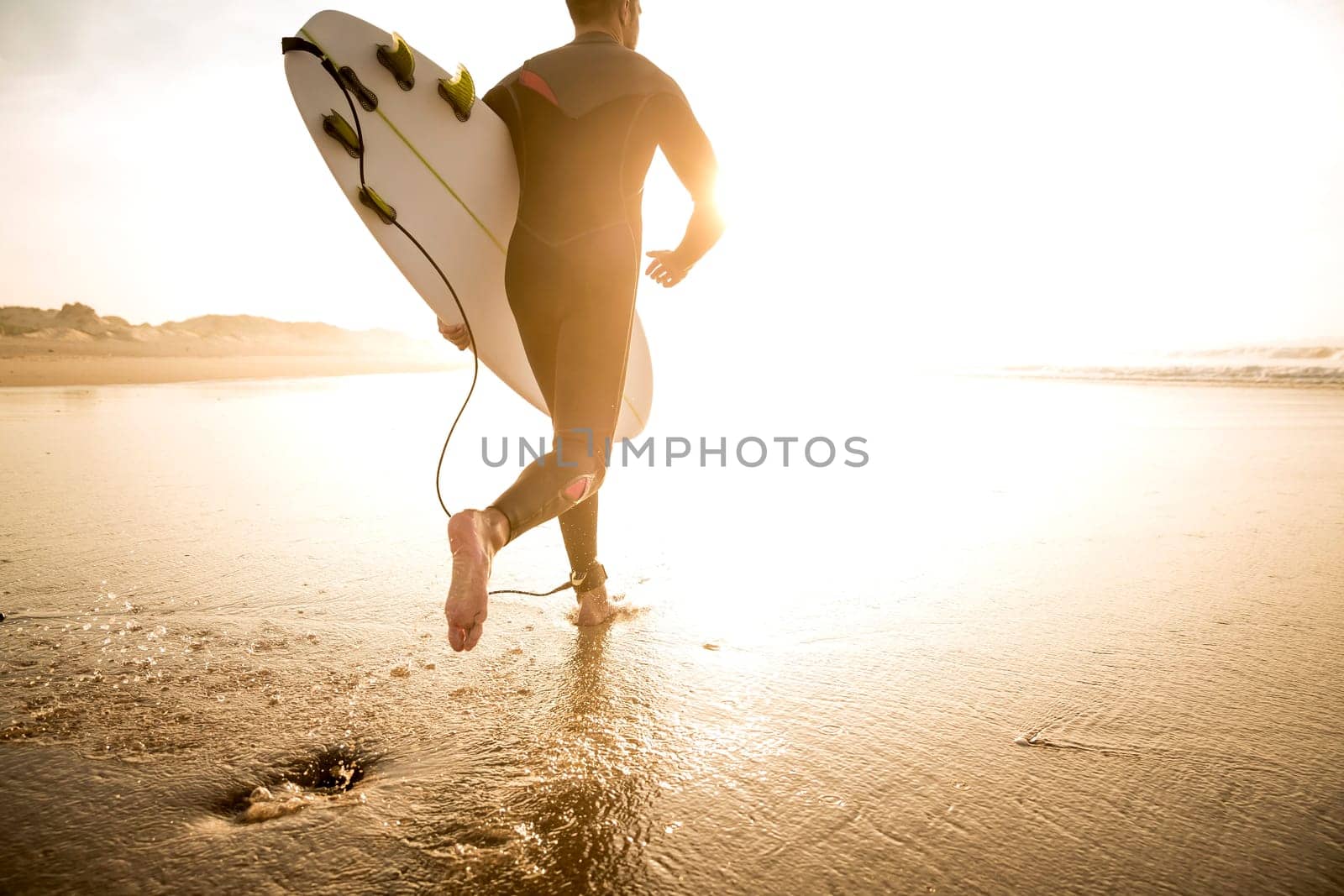 A surfer with his surfboard at the beach