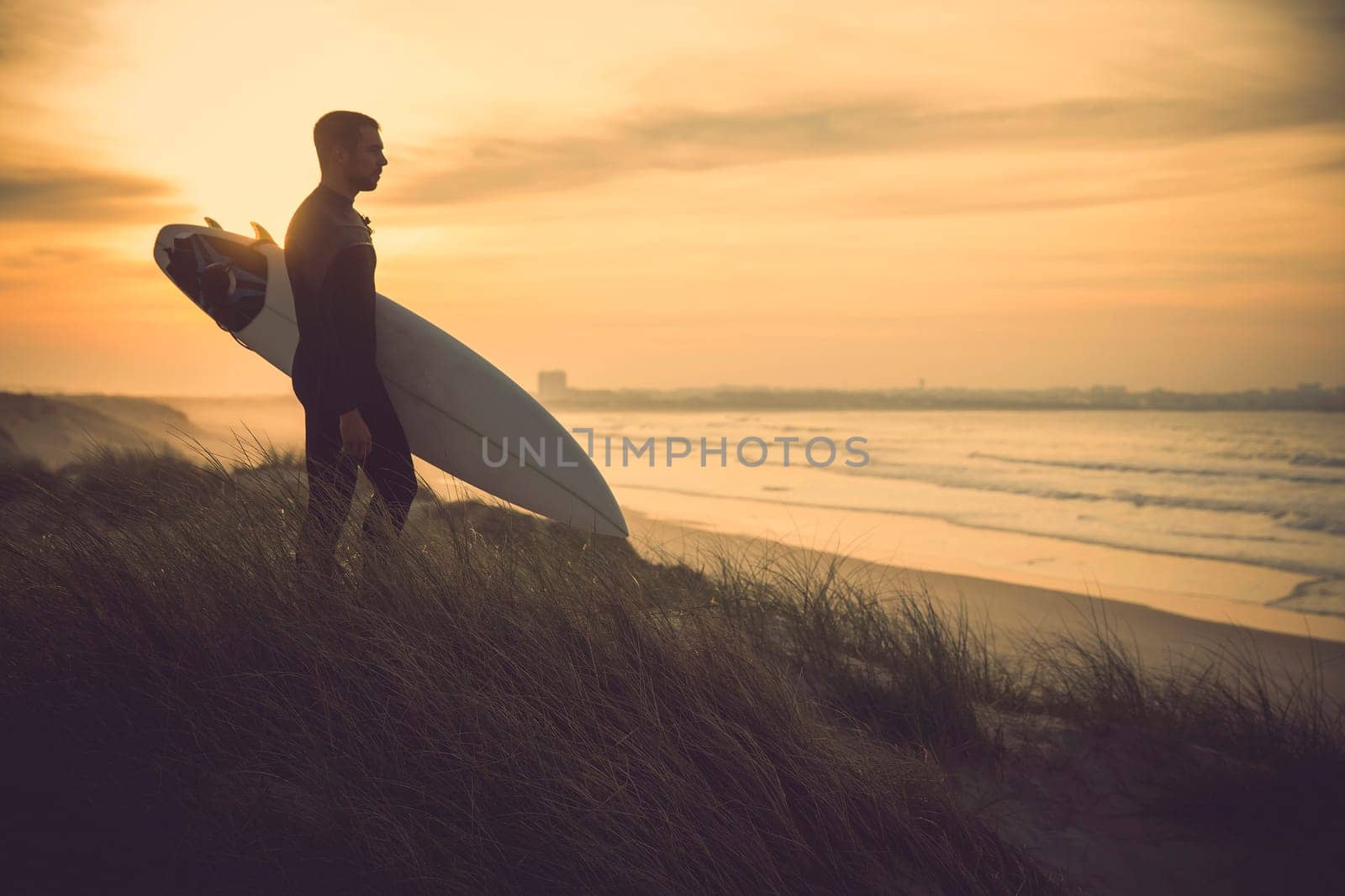 A surfer with his surfboard at the beach