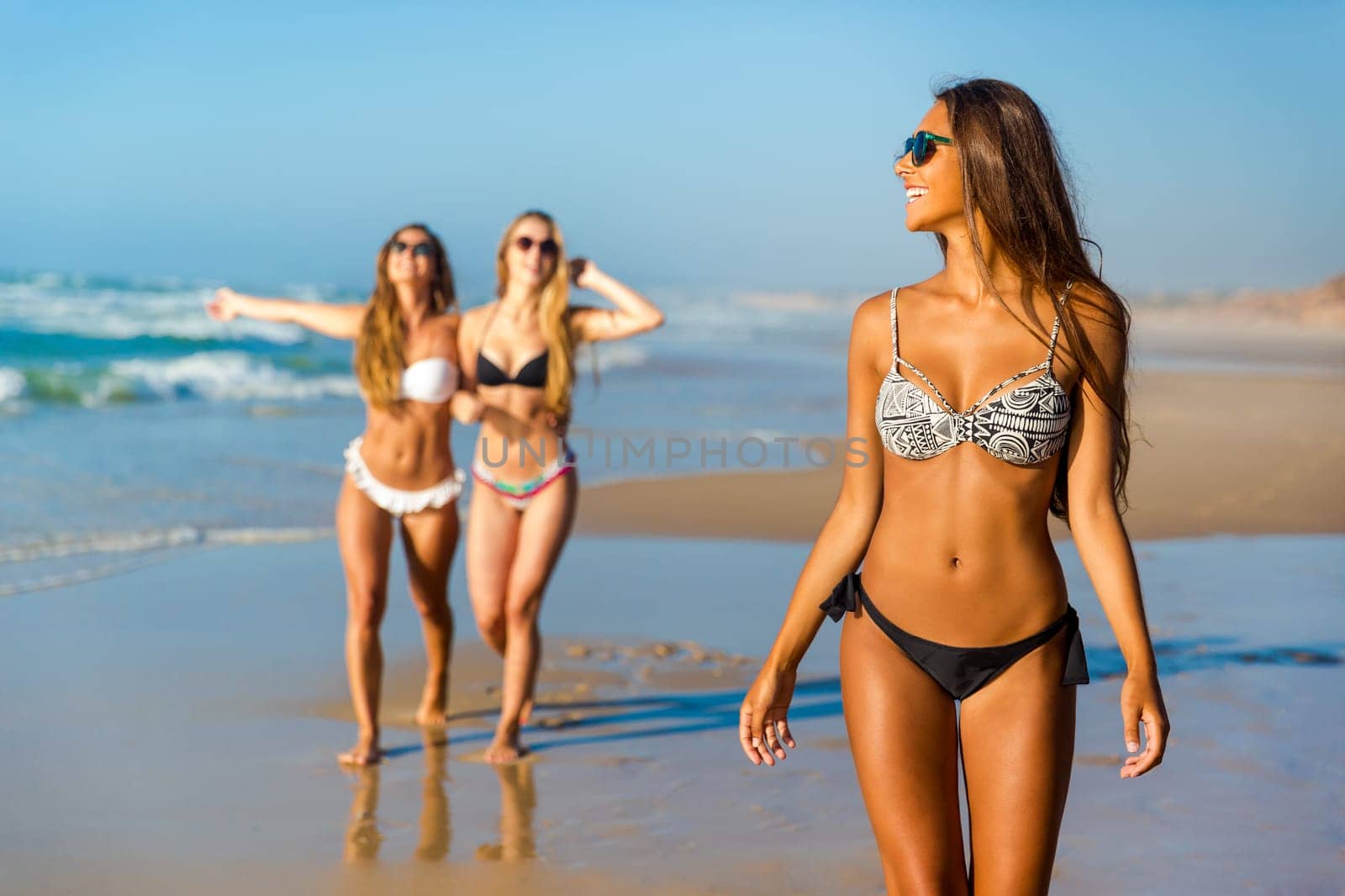 Three beautiful girls having fun on the beach