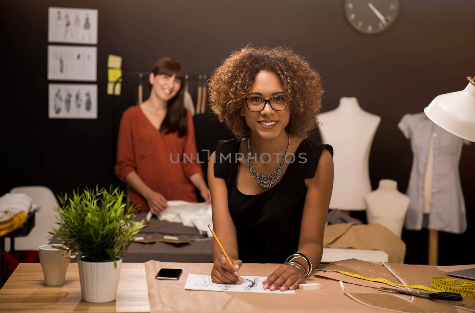 Two young entrepreneur women, and fashion designer working on her atelier