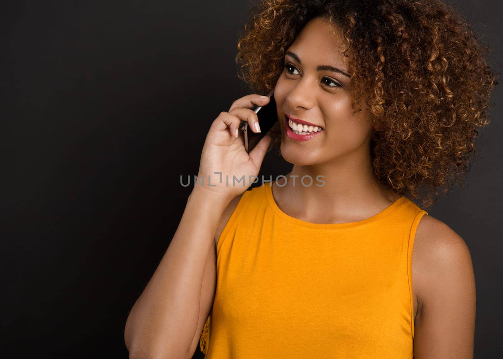 Beautiful African American woman making a phone call and laughing