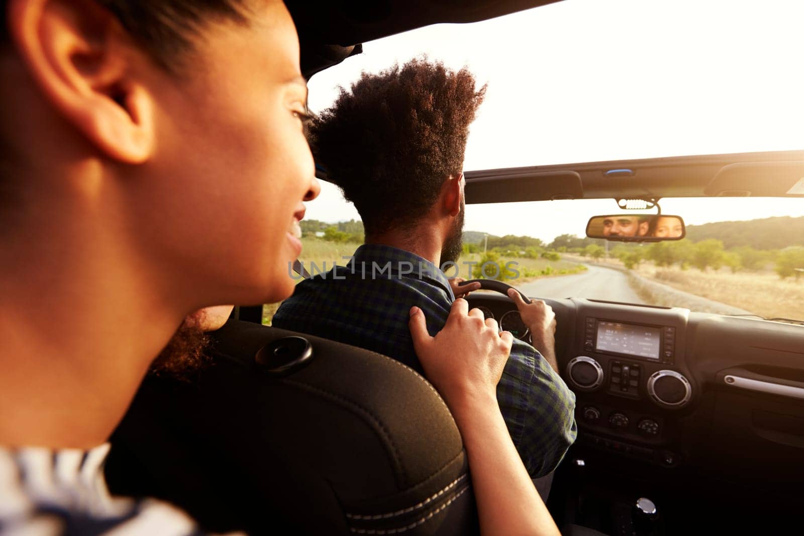 Excited woman in the back of car, hand on shoulder of driver