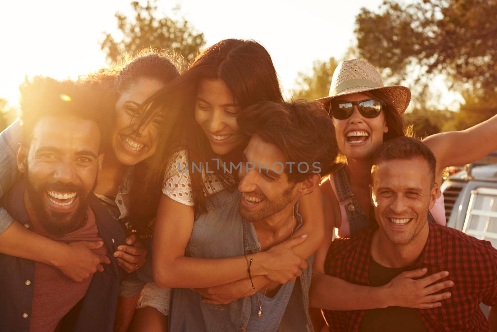 Three couples having fun piggybacking at sundown