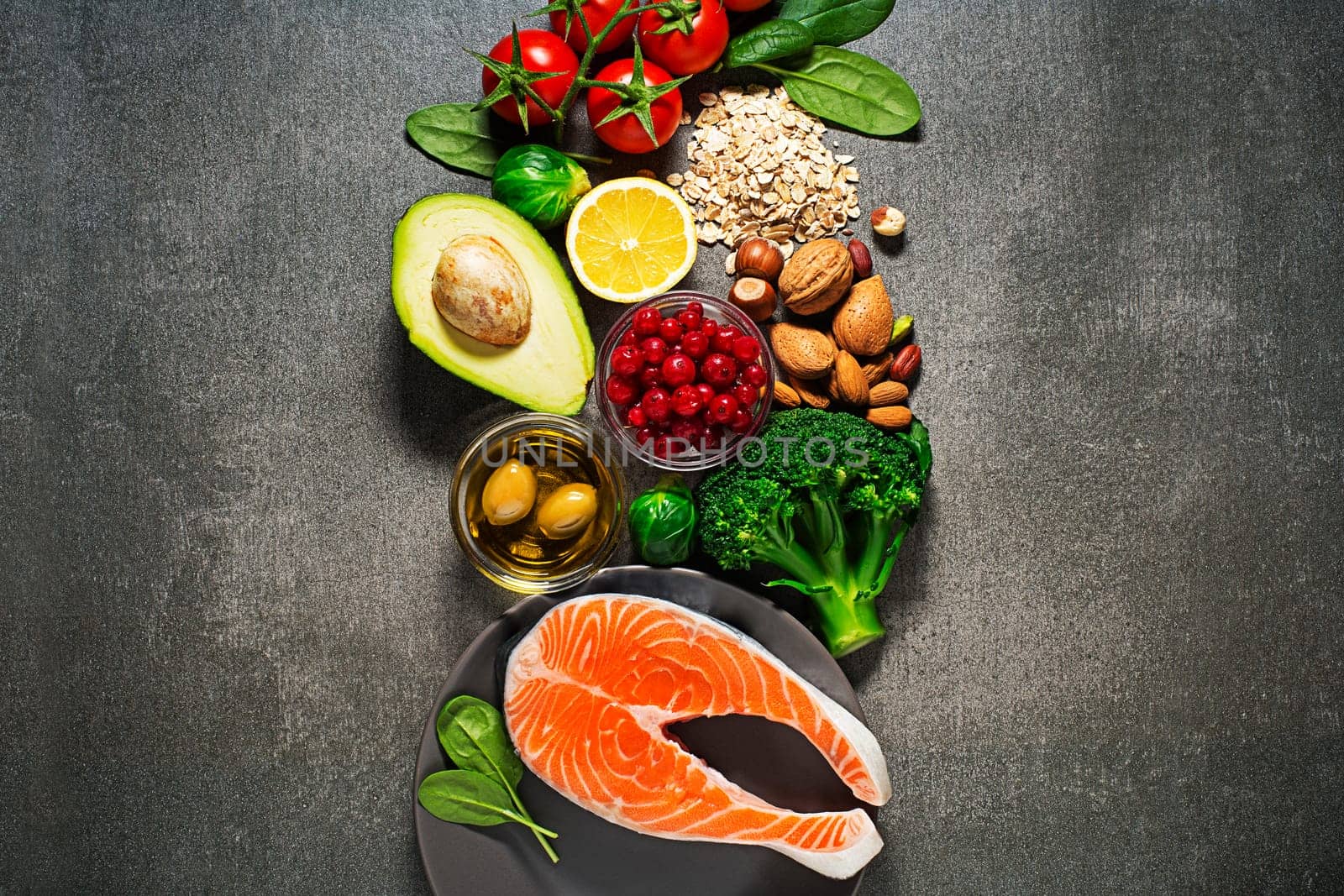 Selection of healthy food. Raw steak of salmon with fresh ingredients on gray background.
