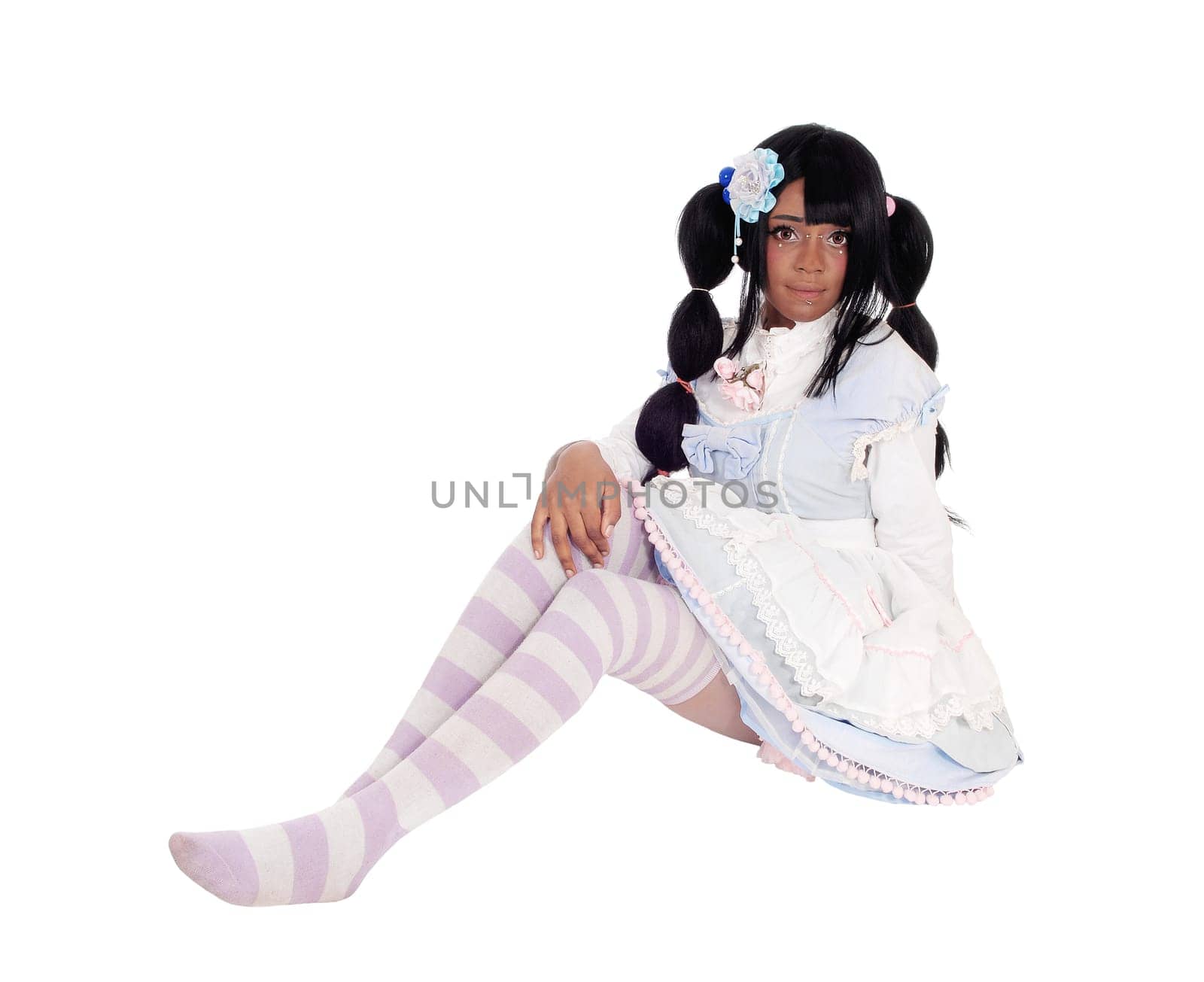 A lovely African American woman sitting on the floor in a short baby doll.dress and long black hair, isolated for white background..