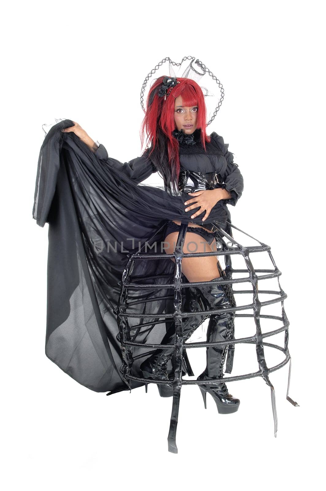 A beautiful African American woman lifting up her black Victorian dress.showing her legs in long black boots, isolated for white background..