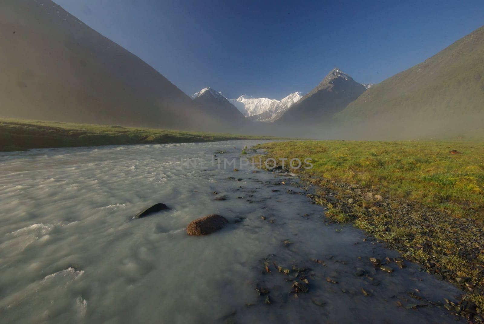 The mountain river in the mountains. Current through the gorge the river. Stones and rocky land near the river. Beautiful mountain landscape.