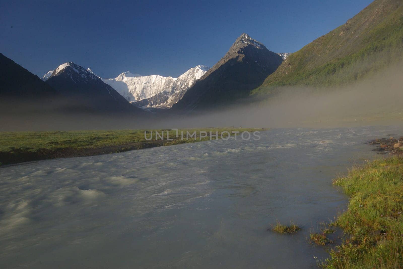The mountain river in the mountains. Current through the gorge the river. Stones and rocky land near the river. Beautiful mountain landscape.