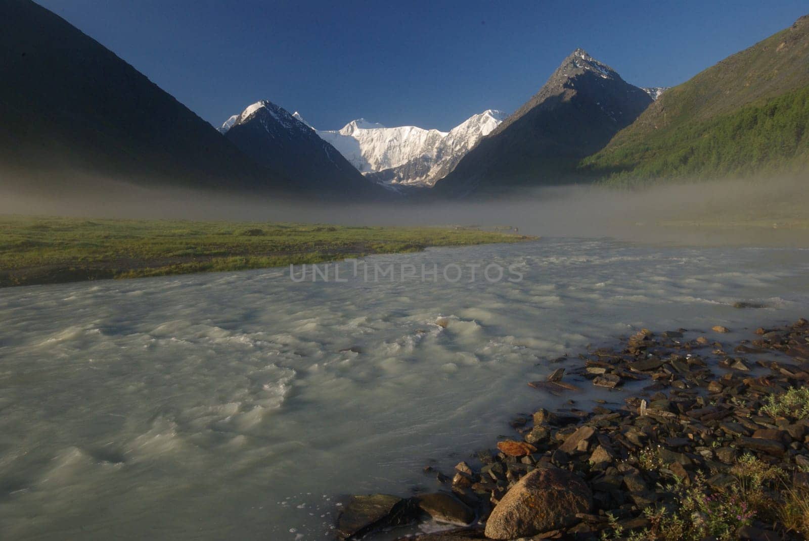 The mountain river in the mountains. Current through the gorge the river. Stones and rocky land near the river. Beautiful mountain landscape.