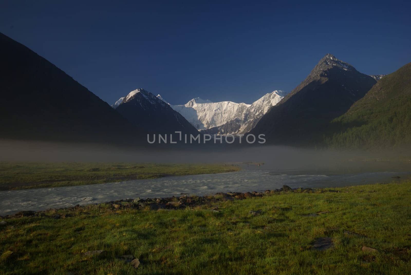 The mountain river in the mountains. Current through the gorge the river. Stones and rocky land near the river. Beautiful mountain landscape.