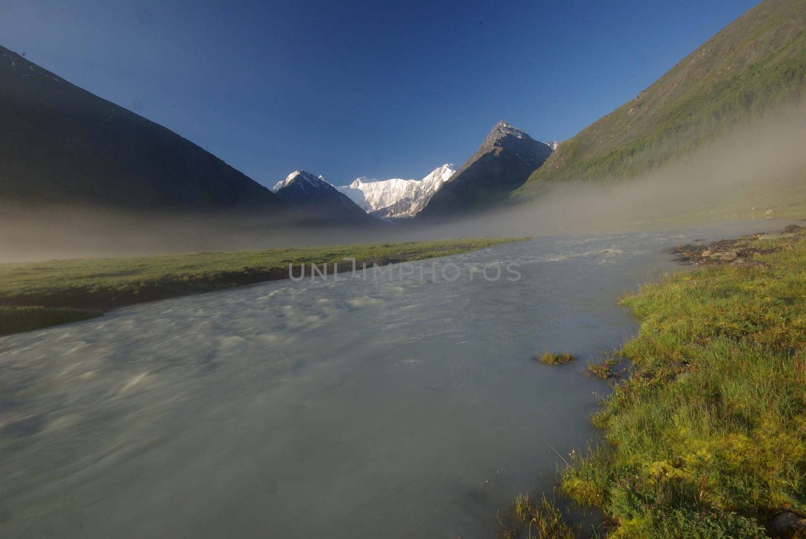 The mountain river in the mountains. Current through the gorge the river. Stones and rocky land near the river. Beautiful mountain landscape.