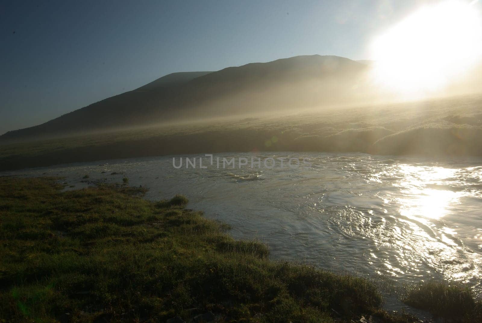The mountain river in the mountains. Current through the gorge the river. Stones and rocky land near the river. Beautiful mountain landscape.