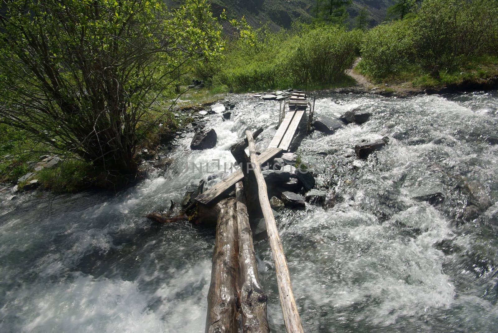 The mountain river in the mountains. Current through the gorge the river. Stones and rocky land near the river. Beautiful mountain landscape.