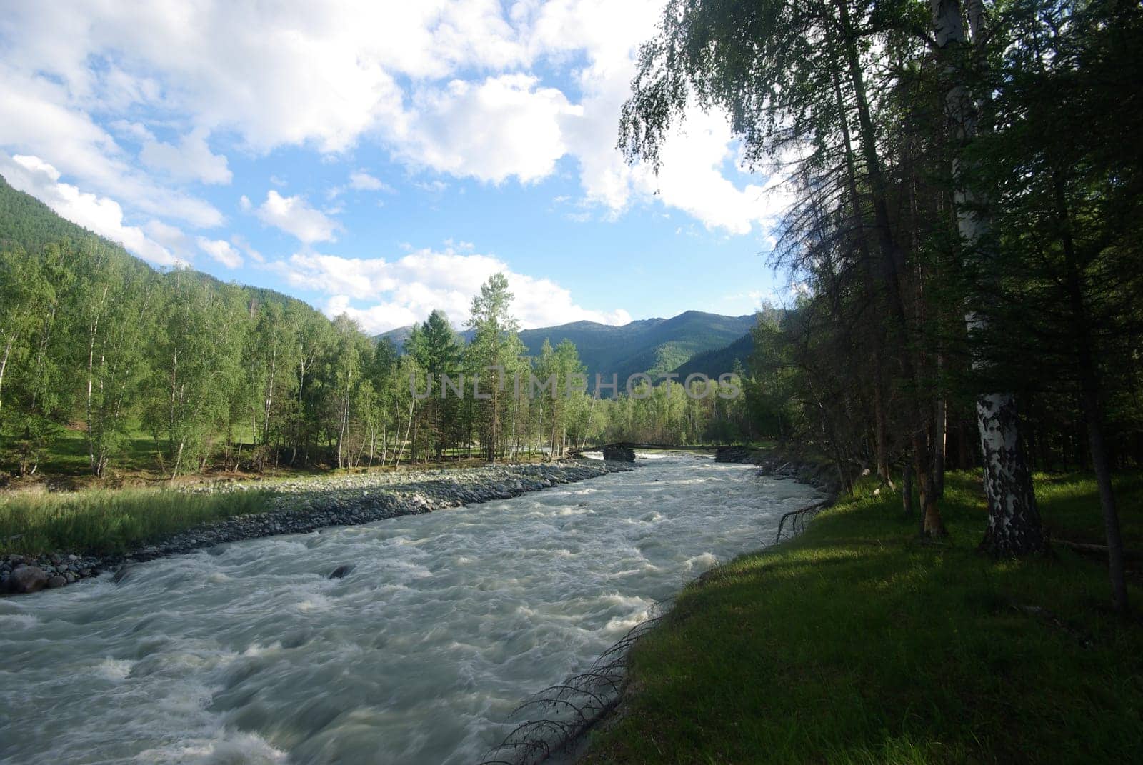 The mountain river in the mountains. Current through the gorge the river. Stones and rocky land near the river. Beautiful mountain landscape.