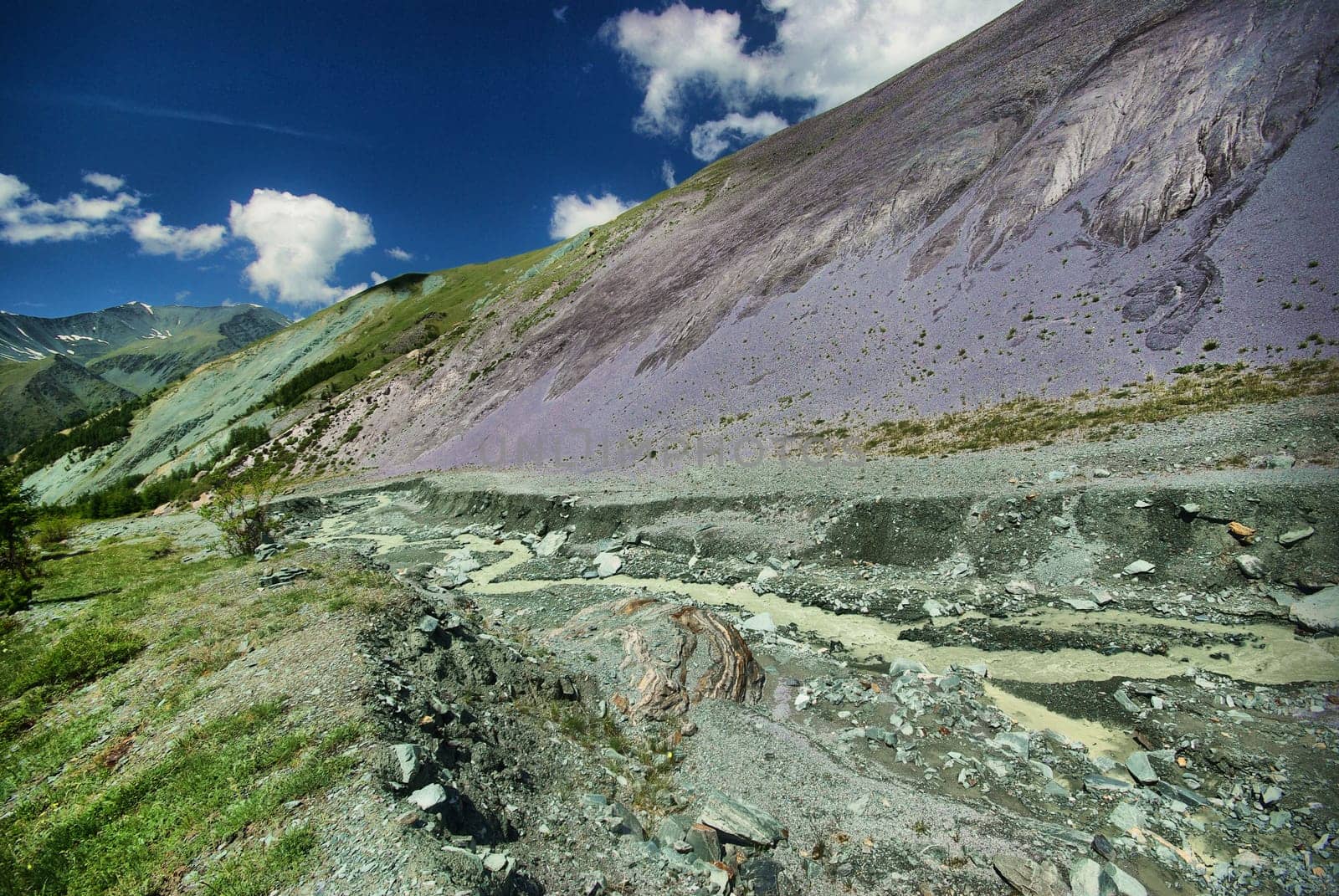 The mountain river in the mountains. Current through the gorge the river. Stones and rocky land near the river. Beautiful mountain landscape.