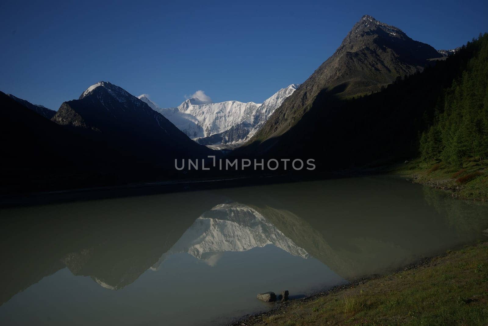 The mountain river in the mountains. Current through the gorge the river. Stones and rocky land near the river. Beautiful mountain landscape.