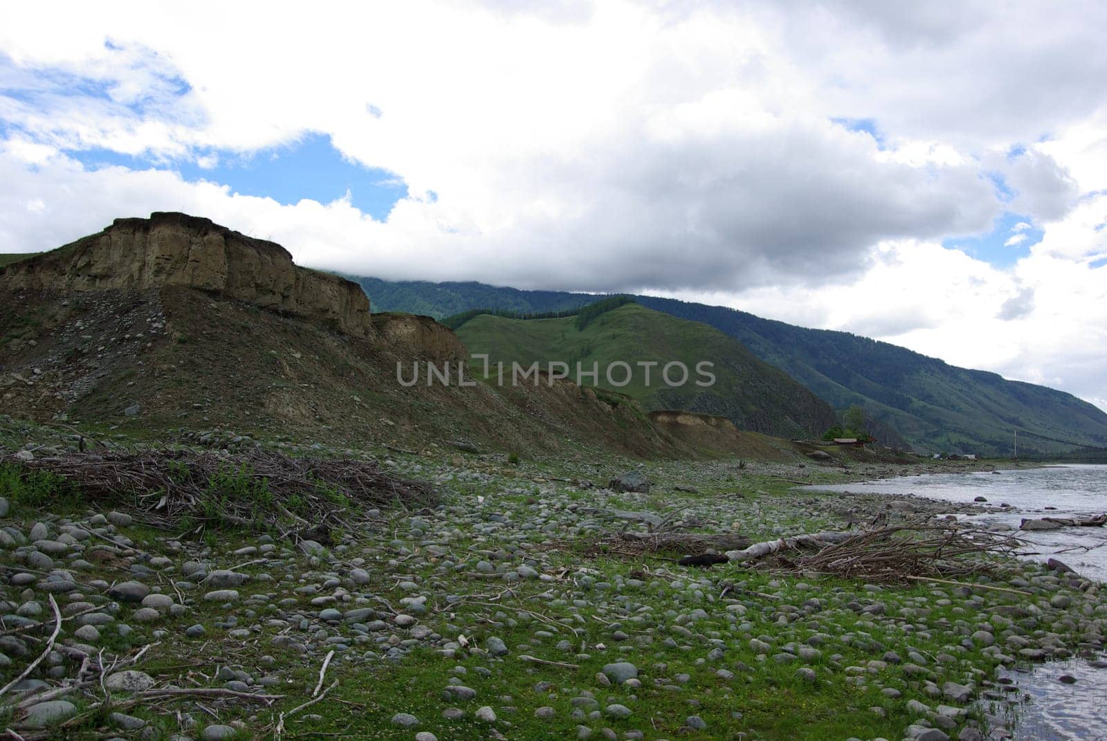 The mountain river in the mountains. Current through the gorge the river. Stones and rocky land near the river. Beautiful mountain landscape.