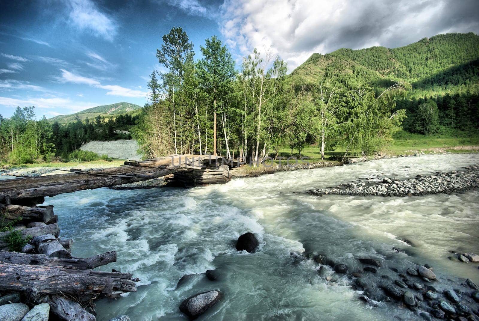The mountain river in the mountains. Current through the gorge the river. Stones and rocky land near the river. Beautiful mountain landscape.
