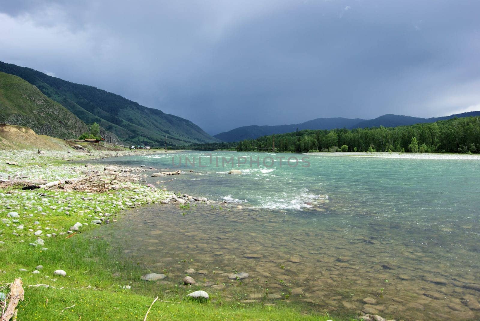 The mountain river in the mountains. Current through the gorge the river. Stones and rocky land near the river. Beautiful mountain landscape.